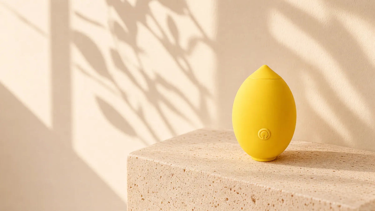 Zest, le stimulateur citron SOOAVA, posé sur une pierre dans la lumière du matin
